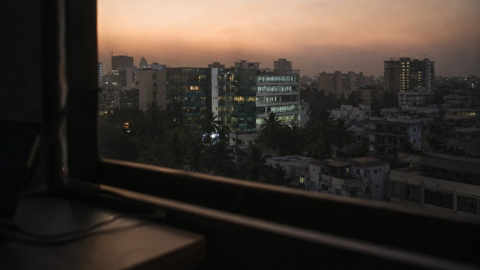 Hyderabad office buildings and rooftops at dusk, seen from a window